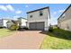 Two-story home with a two-car garage and brick-paved driveway in a modern neighborhood at 581 Sun Warbler Way, St Cloud, FL 34771