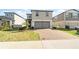 Two-story home with a two-car garage and well-manicured lawn in a modern neighborhood at 581 Sun Warbler Way, St Cloud, FL 34771