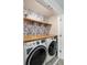 Well-organized laundry room with modern washer and dryer, wooden countertops, and stylish wallpaper at 581 Sun Warbler Way, St Cloud, FL 34771