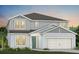 Two-story home with gray siding, white trim, and a two-car garage at 6029 Wildline Dr, St Cloud, FL 34771