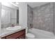 Bathroom with a bathtub, gray tiled walls, and dark brown vanity at 7080 Hemlock Crse, Ocala, FL 34472