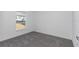 Simple bedroom with gray carpet, white walls, and a window at 7080 Hemlock Crse, Ocala, FL 34472