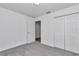 Bright bedroom with grey carpet, double door closet and an additional door at 7080 Hemlock Crse, Ocala, FL 34472