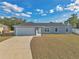 Newly built home with gray exterior, white garage door, and a paved driveway at 7080 Hemlock Crse, Ocala, FL 34472