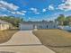 Newly built home with gray exterior, white garage door, and a paved driveway at 7080 Hemlock Crse, Ocala, FL 34472