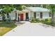 White house with red door, teal roof, and rocking chairs on porch at 750 S Dudley Ave, Bartow, FL 33830