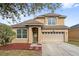 Charming two-story home featuring a manicured lawn, a two-car garage, and welcoming front entrance at 7525 Azalea Cove Cir, Orlando, FL 32807