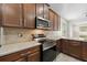 Well-equipped kitchen boasting stainless steel appliances, granite countertops, and wood cabinetry at 7525 Azalea Cove Cir, Orlando, FL 32807