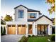 Two-story modern home with light-colored facade, wood garage doors, and landscaping at 785 N Phelps Ave, Winter Park, FL 32789