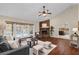 Cozy living room with a brick fireplace, hardwood floors, and French doors leading to the pool at 8620 Willow Kane Ct, Orlando, FL 32835