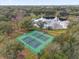 Overhead photograph of tennis courts surrounded by a treed landscape and nearby a pond at 8620 Willow Kane Ct, Orlando, FL 32835