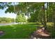 Serene lakefront view with lush green grass and benches at 90 Moree Loop # 16, Winter Springs, FL 32708