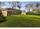 Expansive backyard with green lawn, screened lanai, and mature landscaping at 103 Arrowhead Ct, Winter Springs, FL 32708