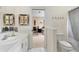 Bathroom leading to bedroom with tiled floor, framed mirror, and built-in towel rack at 103 Arrowhead Ct, Winter Springs, FL 32708