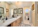 Bathroom featuring double sinks, wood cabinets, framed mirrors, and separate toilet room at 103 Arrowhead Ct, Winter Springs, FL 32708