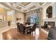 Formal dining room with fireplace, coffered ceiling, wood floors, and views of the pool and patio at 103 Arrowhead Ct, Winter Springs, FL 32708