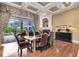 Dining room with wood floors, fireplace, coffered ceiling, and backyard pool view at 103 Arrowhead Ct, Winter Springs, FL 32708