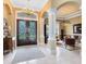 Elegant foyer featuring double doors, tile flooring, decorative columns, and a grand chandelier at 103 Arrowhead Ct, Winter Springs, FL 32708