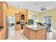 Bright kitchen with an island, granite counters, light wood cabinets, and stainless steel appliances at 103 Arrowhead Ct, Winter Springs, FL 32708