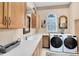 A modern laundry room features a side-by-side washer and dryer, cabinets and lots of counter space at 103 Arrowhead Ct, Winter Springs, FL 32708