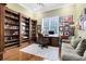 Spacious home office with custom built-in bookshelves, hardwood floors, and a large window for natural light at 103 Arrowhead Ct, Winter Springs, FL 32708