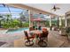 Covered outdoor patio featuring a private pool, dining area, and a built-in bar for entertaining at 103 Arrowhead Ct, Winter Springs, FL 32708