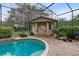 A luxurious outdoor pool area featuring a covered bar area and lush landscaping at 103 Arrowhead Ct, Winter Springs, FL 32708