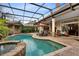 Outdoor pool area showcasing outdoor dining, screened-in enclosure, brick pavers and lush landscape at 103 Arrowhead Ct, Winter Springs, FL 32708