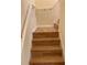 Modern stairs with light brown wood-look laminate and white railing at 10975 Savannah Landing Cir, Orlando, FL 32832