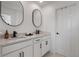 Elegant bathroom with double vanity and two large mirrors at 11574 Buoy Point Pl, Orlando, FL 32832