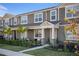 Townhome with light brown siding, a beige door, and palm trees at 11574 Buoy Point Pl, Orlando, FL 32832