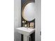 Chic powder room with a pedestal sink and a gold framed mirror at 11574 Buoy Point Pl, Orlando, FL 32832