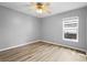 Simple bedroom with wood-look floors and a window with natural light at 1210 Kenway Ave, Deltona, FL 32738