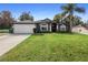 Gray house with white garage door, landscaping, and columns at 1210 Kenway Ave, Deltona, FL 32738