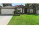 Gray house with white garage door and green lawn at 1210 Kenway Ave, Deltona, FL 32738