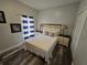 Cozy bedroom features a queen bed, striped curtains, and wood-look flooring at 1230 Las Fuentes Dr, Kissimmee, FL 34746