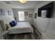 Comfortable bedroom features a queen bed, stylish lamps, and wood-look flooring at 1230 Las Fuentes Dr, Kissimmee, FL 34746