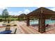Community pool with covered lounge area, water fountain, lounge chairs, and lush landscaping at 1230 Las Fuentes Dr, Kissimmee, FL 34746