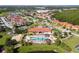 Aerial view of a large community pool surrounded by palm trees, sun loungers, and a well maintained club house at 1230 Las Fuentes Dr, Kissimmee, FL 34746