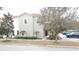 Charming two-story home with a well-manicured lawn, neat shrubbery, and mature trees lining the driveway at 1230 Las Fuentes Dr, Kissimmee, FL 34746