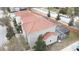 Aerial view of a home with a screened-in pool area and a red tile roof and well manicured lawn at 1230 Las Fuentes Dr, Kissimmee, FL 34746