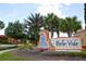 Entrance sign to Bella Vida with palm trees and blue sky in the background at 1230 Las Fuentes Dr, Kissimmee, FL 34746