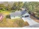 Single story house with gray roof, and a paved driveway at 1267 Varnado Rd, Groveland, FL 34736