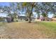 Large backyard with mature trees, showing home's rear elevation at 1267 Varnado Rd, Groveland, FL 34736