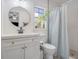 Modern bathroom with white vanity, walk-in shower, and a round mirror at 1267 Varnado Rd, Groveland, FL 34736