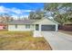 Single-story home with light green exterior, attached garage, and landscaping at 1267 Varnado Rd, Groveland, FL 34736