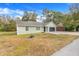 Single-story home with light green exterior, attached garage, and landscaping at 1267 Varnado Rd, Groveland, FL 34736