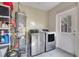 Laundry room with washer, dryer, water heater, and storage shelves at 1267 Varnado Rd, Groveland, FL 34736