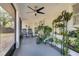 Bright screened porch with ceiling fan, rocking chairs, and numerous plants at 1267 Varnado Rd, Groveland, FL 34736