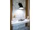 Modern bathroom vanity with marble-look wall and black sconce at 13586 Abberwick Dr, Orlando, FL 32832